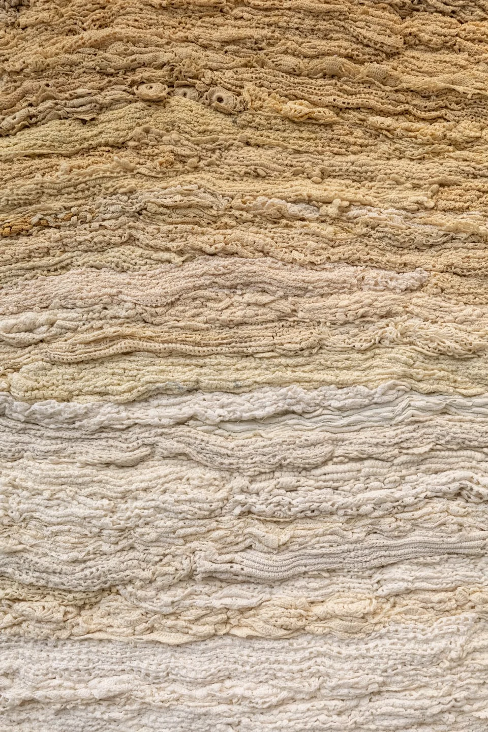 Layers of textured textile in warm sand, oatmeal and ivory tones